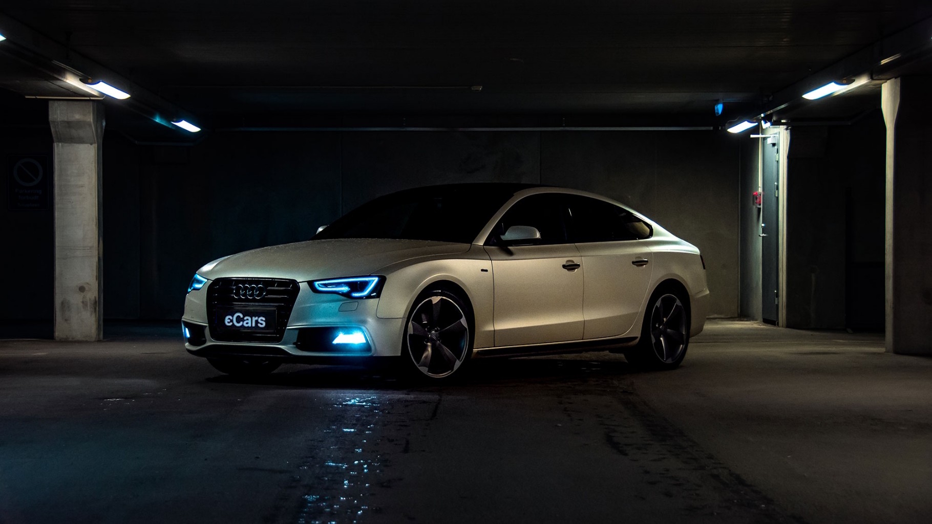 Audi в підземному паркінгу з увімкненими фарами